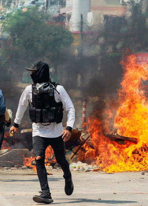 An anti-coup protesters sets fire on the road