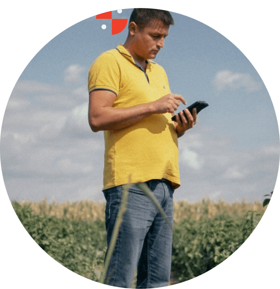A male farmer standing in a field consulting an app on his smartphone in Serbia