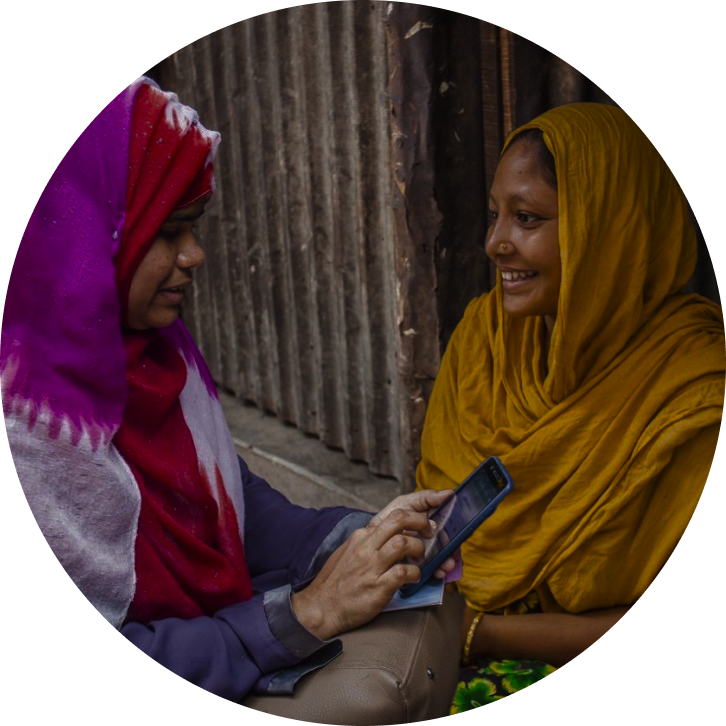 Two women outside in discussion while using a smartphone app in Sri Lanka