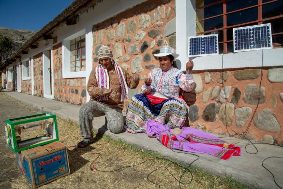 2 artisans weaving in front of the house